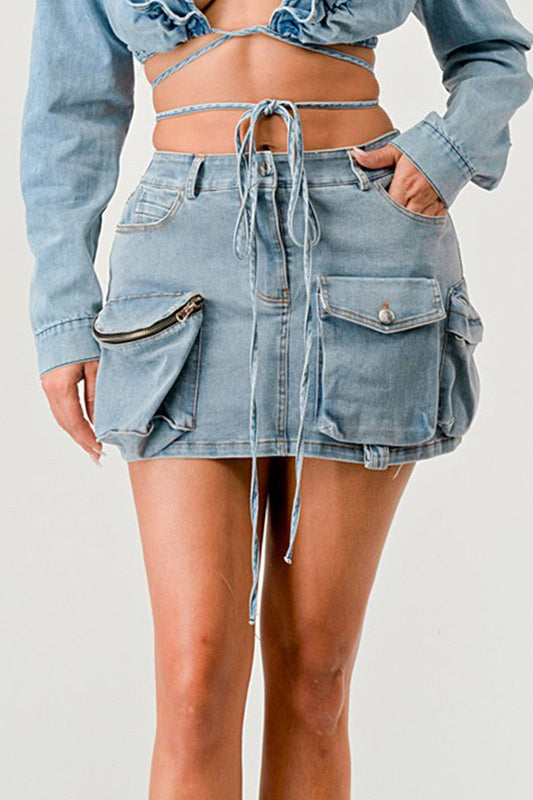 Model wearing a denim wrap skirt with adjustable drawstrings and side pockets, showcasing a modern and playful design.