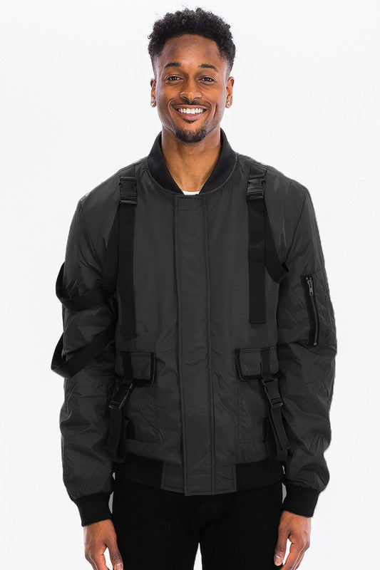 A person wearing a tactical utility bomber jacket featuring straps and buckles, showcasing its stylish design.
