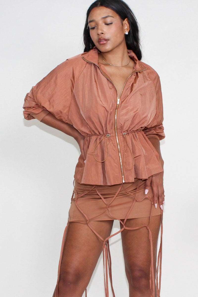 Desert Rose windbreaker skirt set featuring a cinched waist windbreaker with tassel details for a chic look.