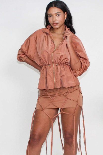 Desert rose windbreaker skirt set featuring a cinched waist windbreaker and tassel skirt.