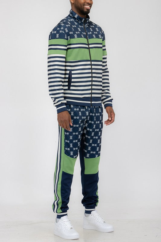 Man wearing a stylish chain link track suit featuring a long sleeve zip jacket and matching jogger pants.