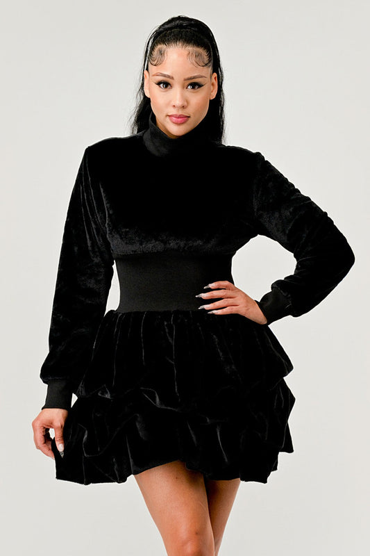 Model wearing a Merry Go Around Ruffle long sleeve dress in black, showcasing its playful ruffles and chic style.