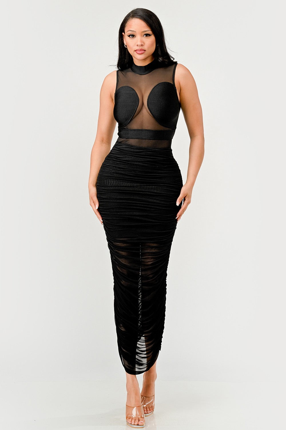 Sleek black sheer illusion midi dress featuring a high-neck sheer top and ruched black skirt.