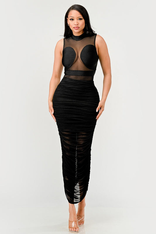 Sleek black sheer illusion midi dress featuring a high-neck sheer top and ruched black skirt.