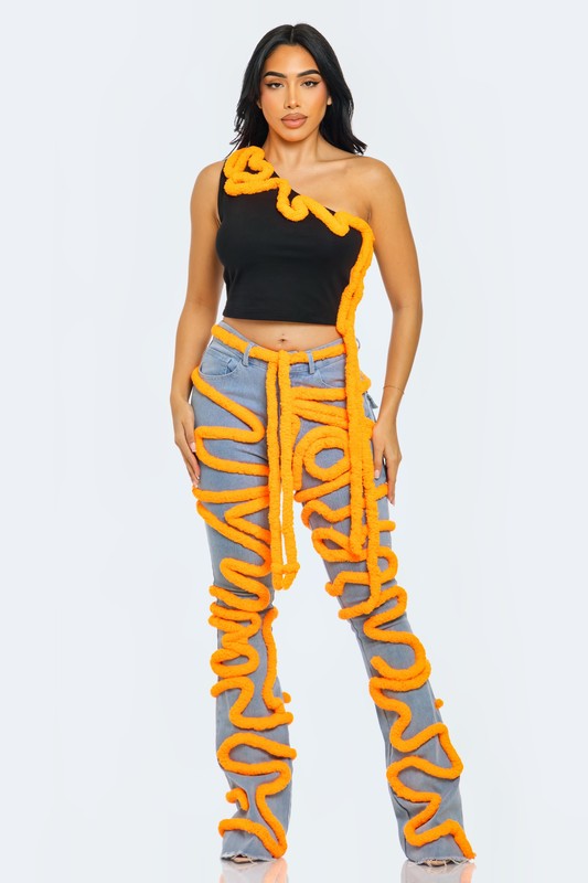 Asymmetrical crop top with contrast orange piping, styled with unique orange-detail pants, showcasing a bold fashion statement.