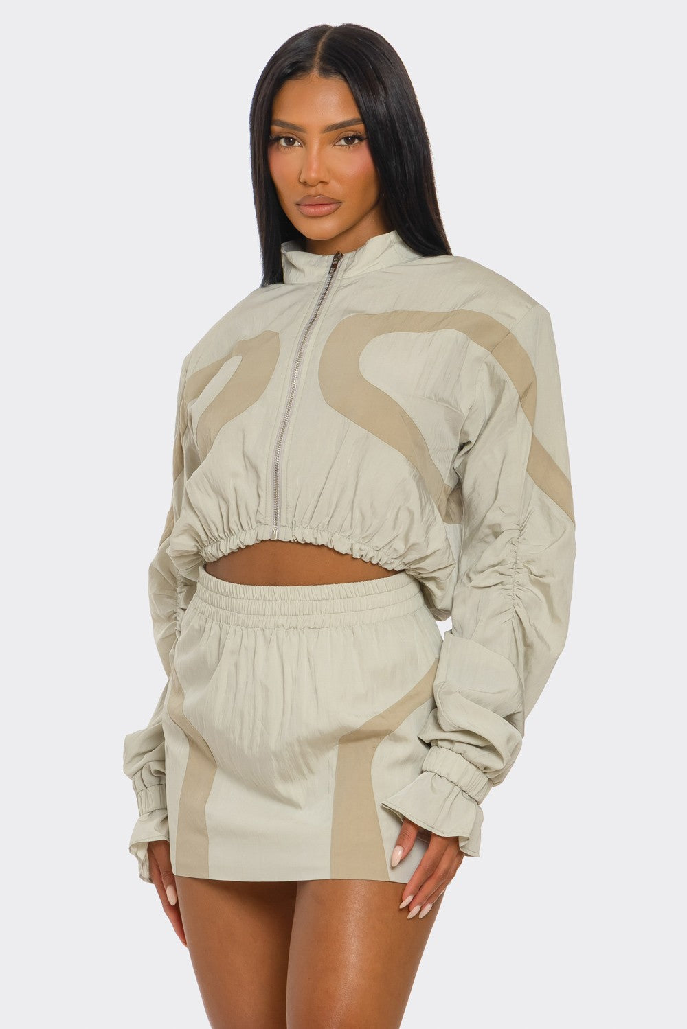 Two-tone windbreaker skirt set featuring a cropped jacket and mini skirt in light hues.
