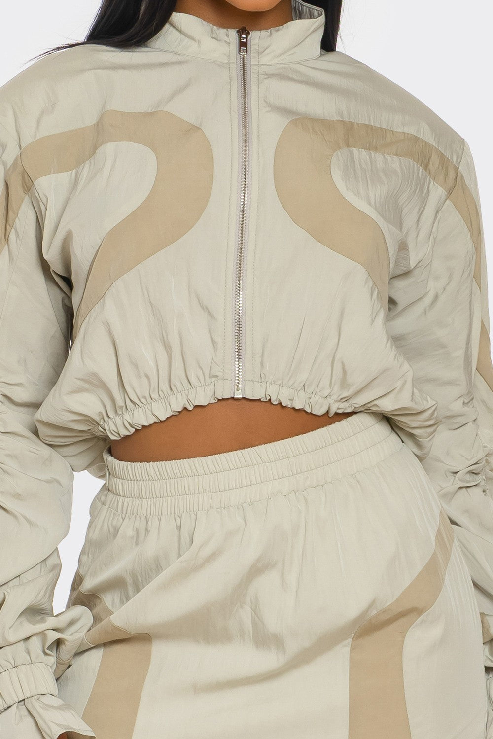 Two-Tone Nylon Windbreaker Skirt Set featuring a cropped zip-up jacket and high-rise mini skirt in light tones.