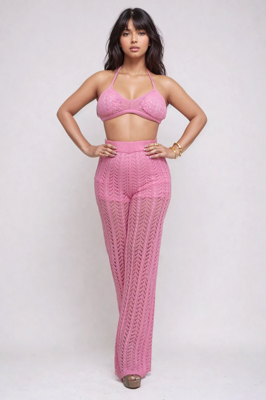 Model wearing a pink crochet halter and pant set, showcasing the classic triangle halter top and high-waisted wide-leg pants.