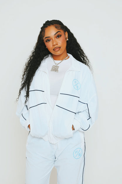 A model wearing a lightweight utility windbreaker jacket and matching pants against a plain background.