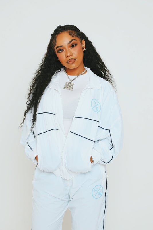 A model wearing a lightweight utility windbreaker jacket and matching pants against a plain background.