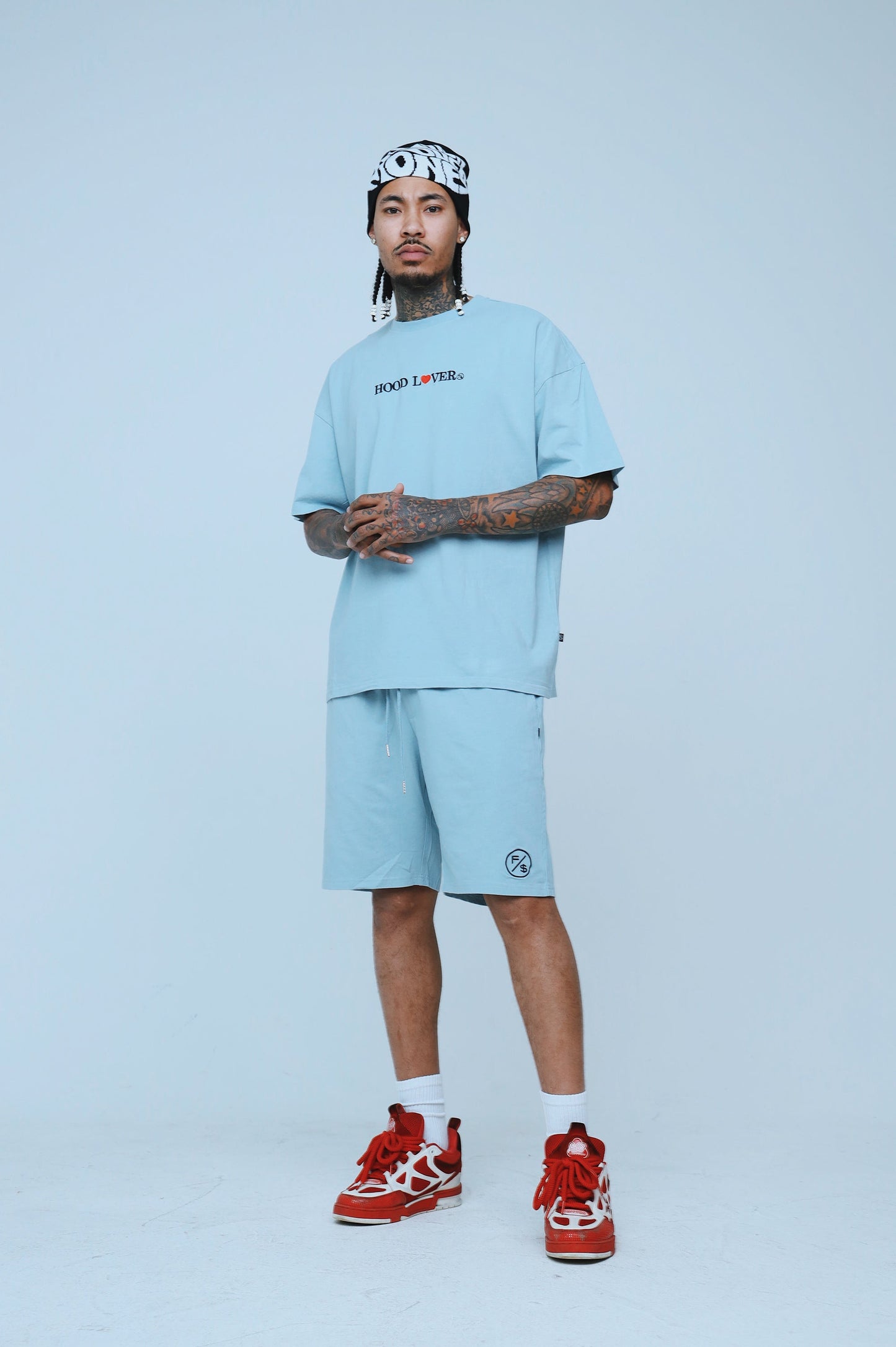 Man wearing oversized streetwear shorts paired with a matching tee, showcasing a relaxed fit and stylish streetwear vibe.