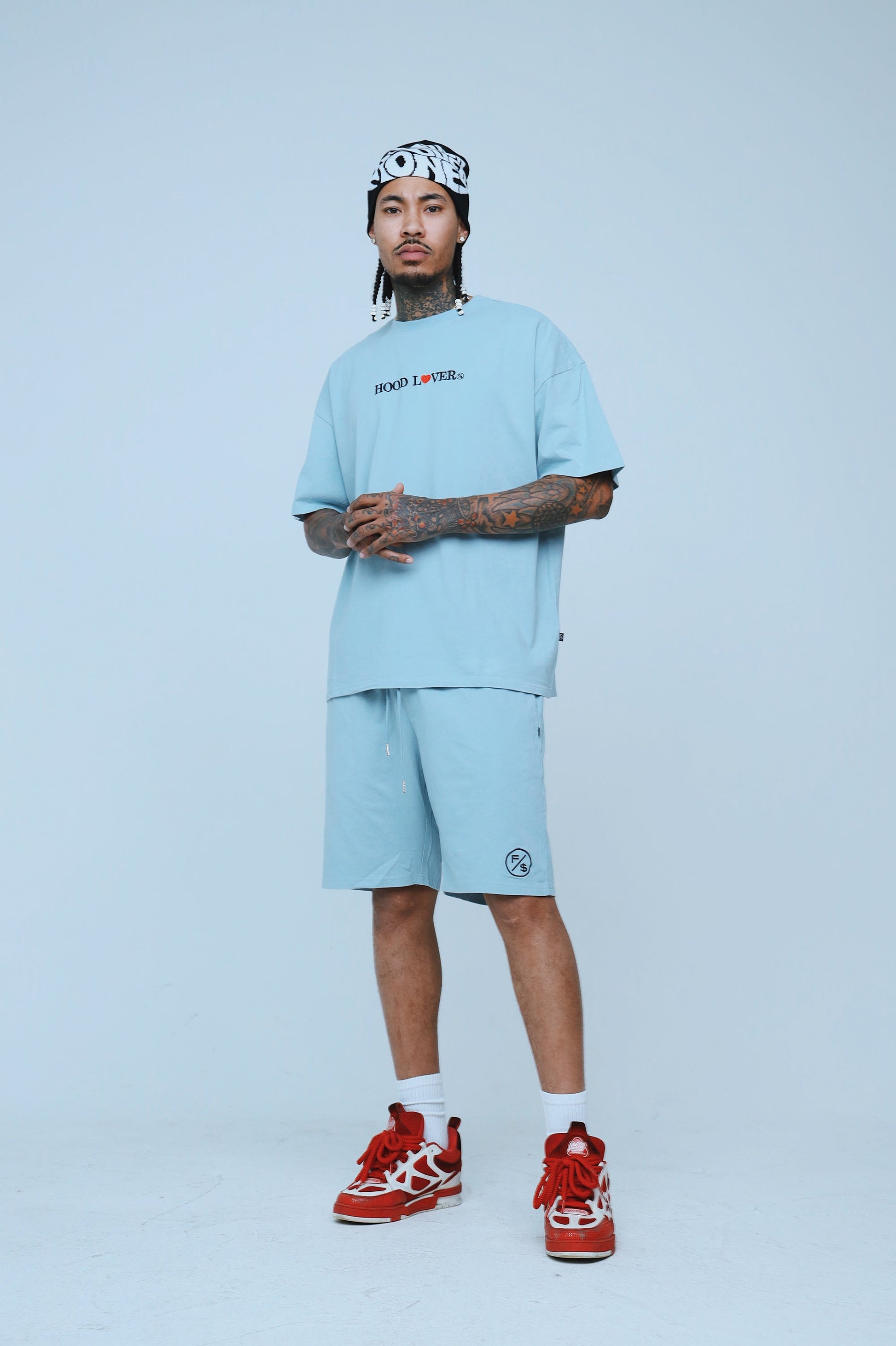 Man wearing oversized streetwear shorts paired with a matching tee, showcasing a relaxed fit and stylish streetwear vibe.