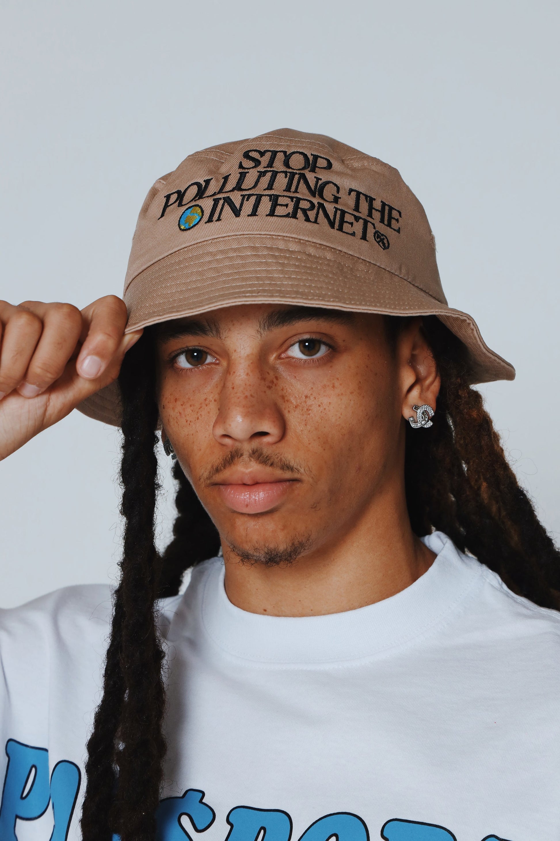 Unisex statement bucket hat with graphic featuring 'Stop Polluting the Internet' message, modeled by individual.