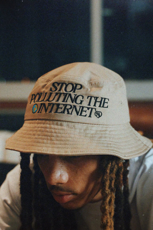Unisex statement bucket hat with graphic featuring 'Stop Polluting the Internet' design worn by a model.