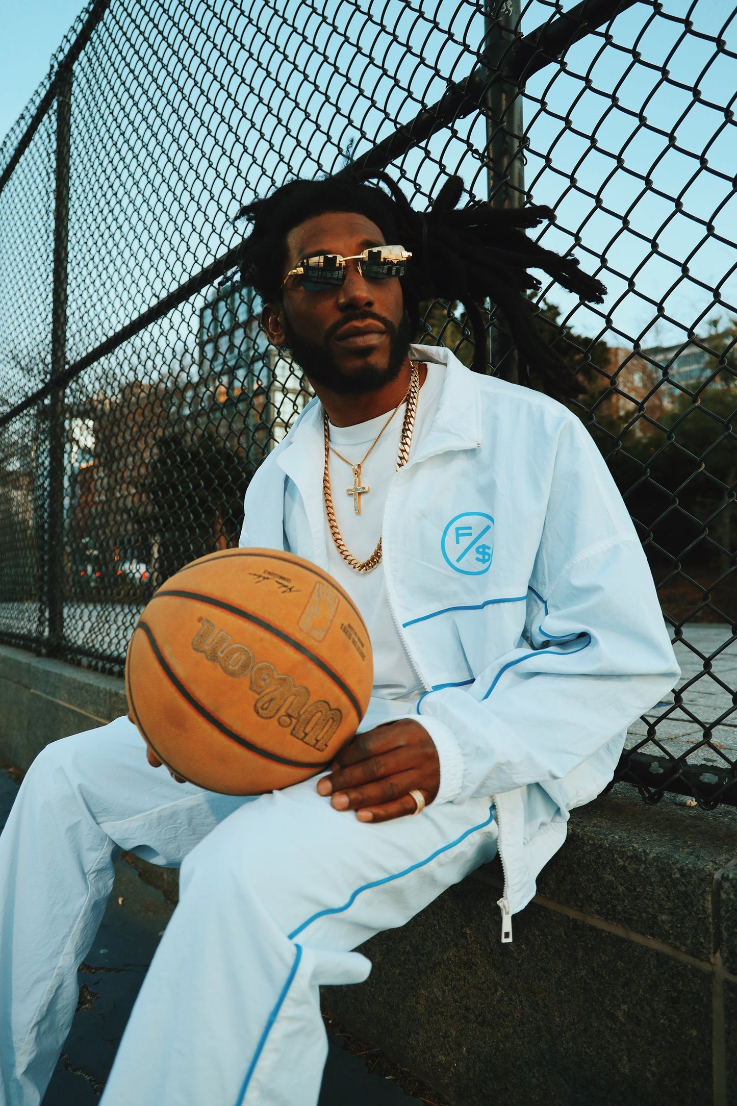 Lightweight utility windbreaker jacket worn by man holding a basketball, showcasing modern streetwear style.