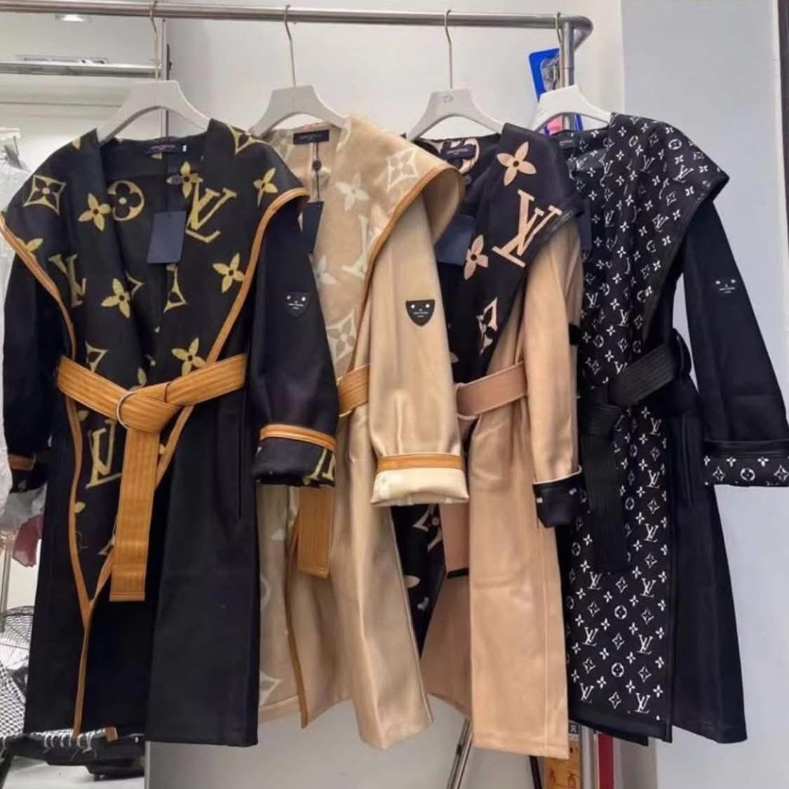Luxury reversible monogram trench coat in various styles displayed on hangers, showcasing rich patterns and high-end detailing.