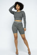 Model showcasing a knit long sleeve cropped top and biker shorts set in stylish gray pattern.
