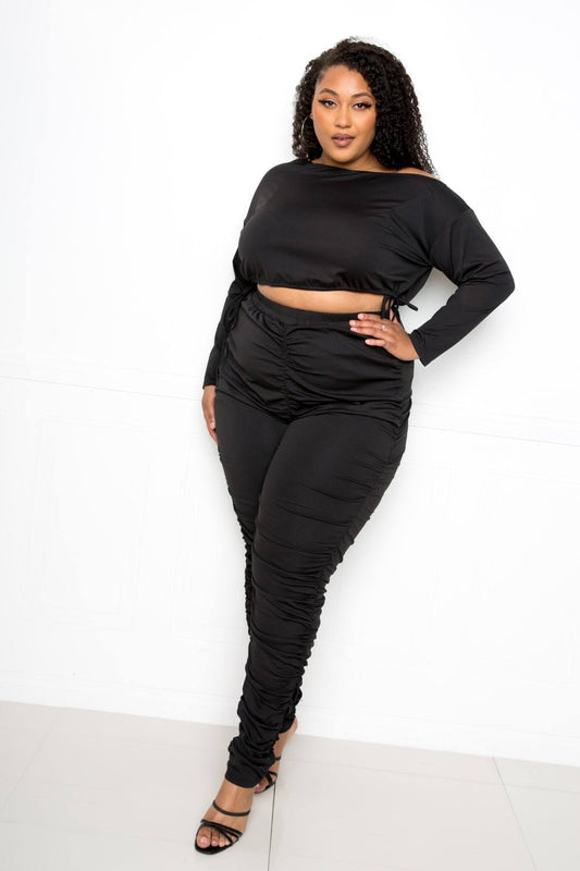 Plus size off shoulder cropped top set featuring a stylish black ensemble with ruched leggings.