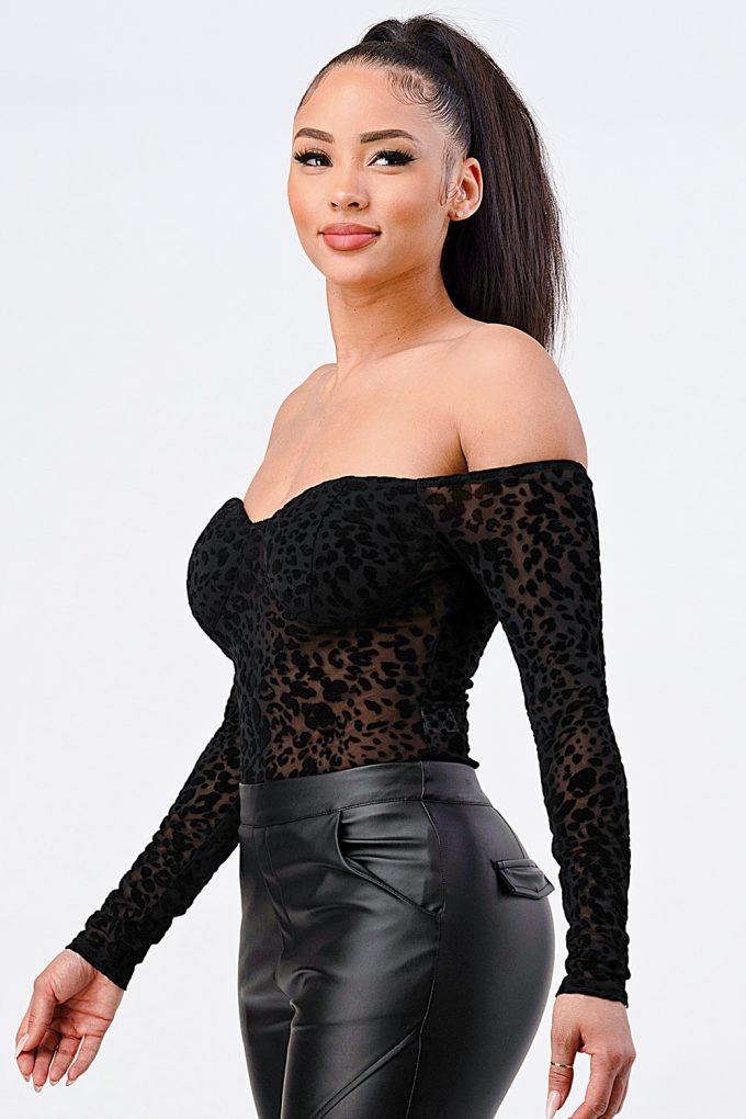 Young woman modeling a leopard print off shoulder bodysuit with black pants.