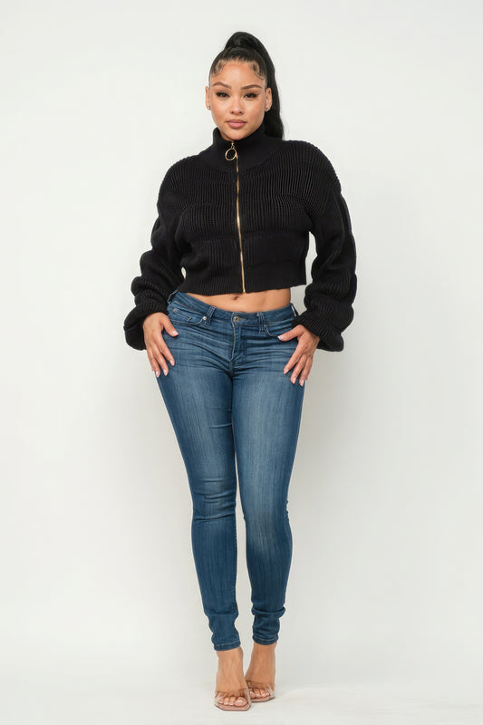 Michelin sweater top with front zipper paired with stylish jeans and heels on a model.