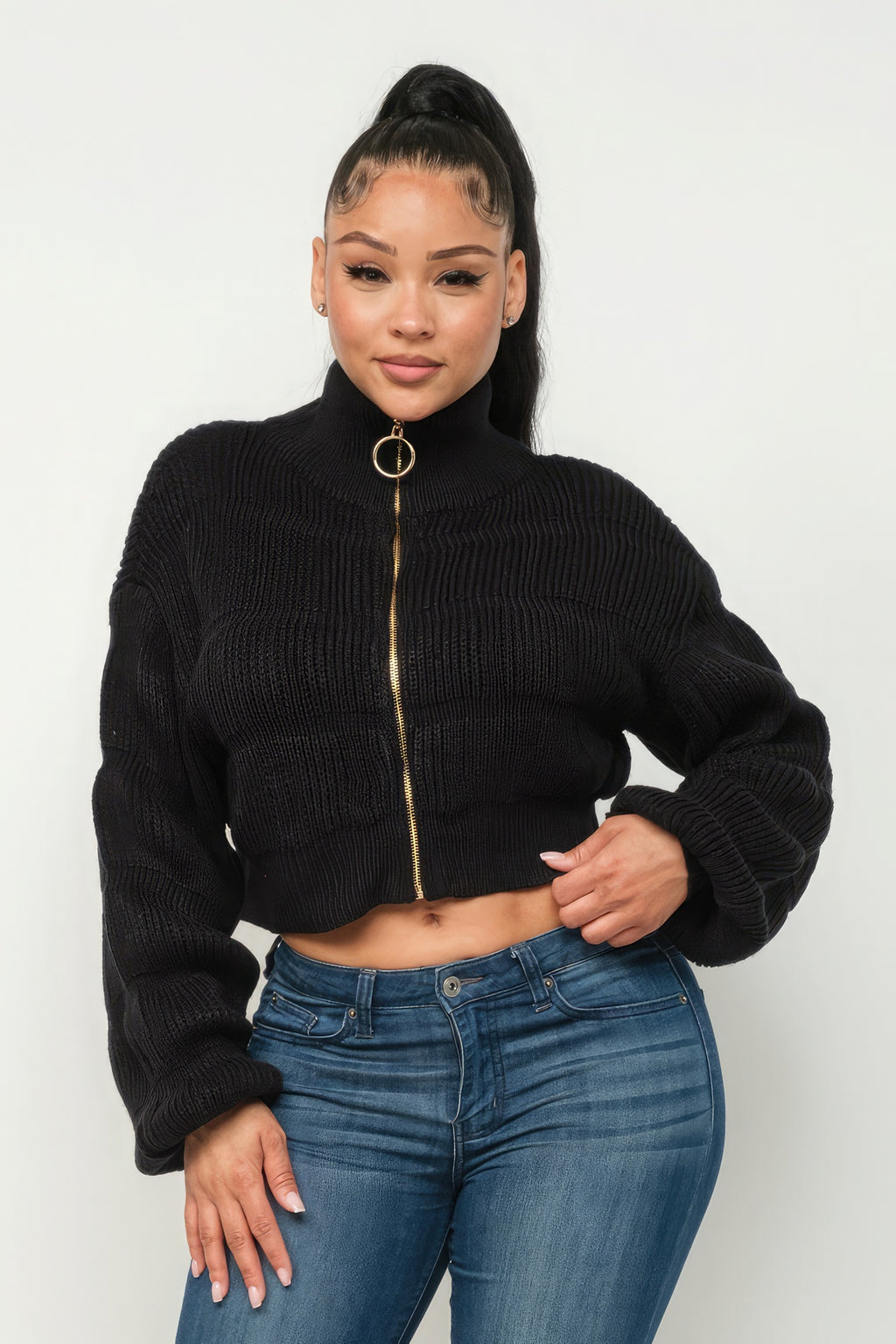 Model showcasing Michelin sweater top with front zipper over blue jeans, featuring a stylish cropped design.