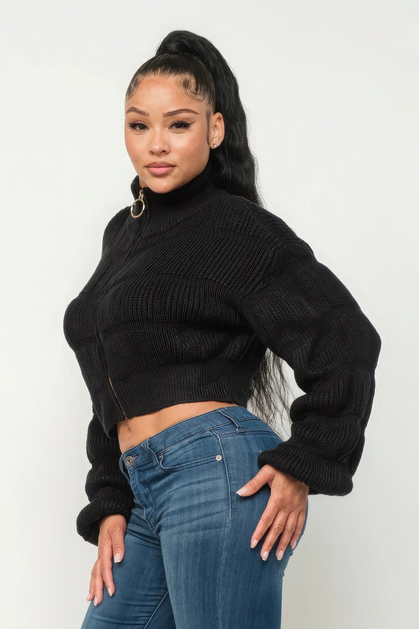 Model showcasing Michelin sweater top with front zipper in black, paired with blue jeans, stylish and modern look.