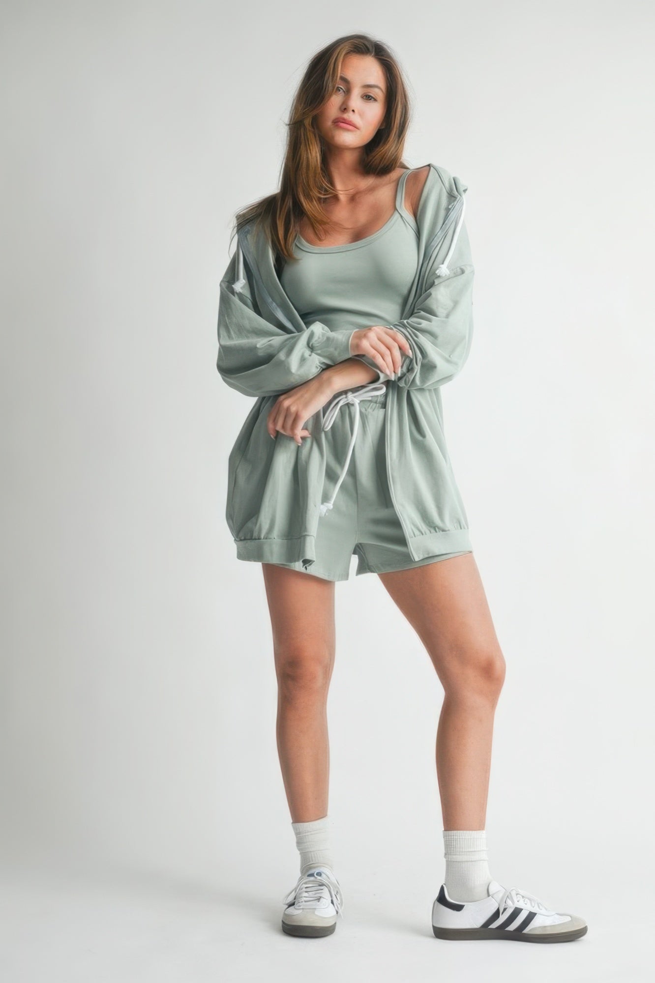 Model showcasing a stylish outfit featuring a comfortable rose cotton sweater set with shorts and a lightweight jacket.