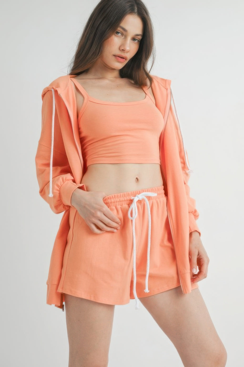 Model wearing the rose cotton sweater set featuring a cropped top and shorts in a vibrant peach color.