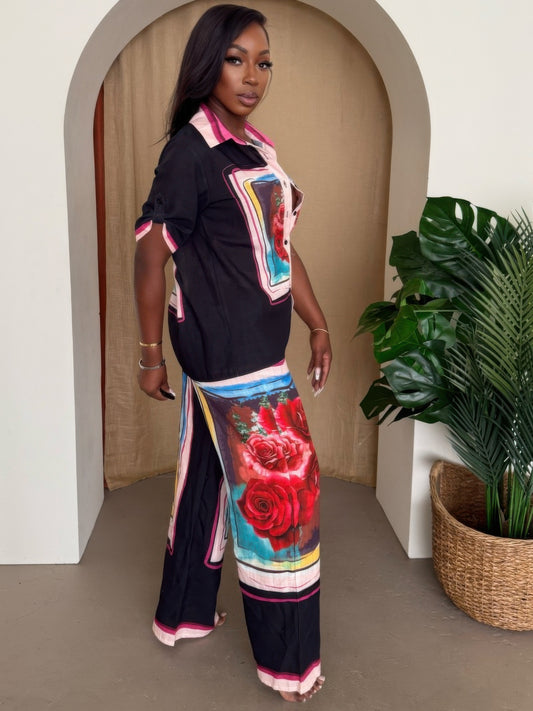 A model wearing a rose print lounge set featuring a button-up top and wide-leg pants with bold red roses.