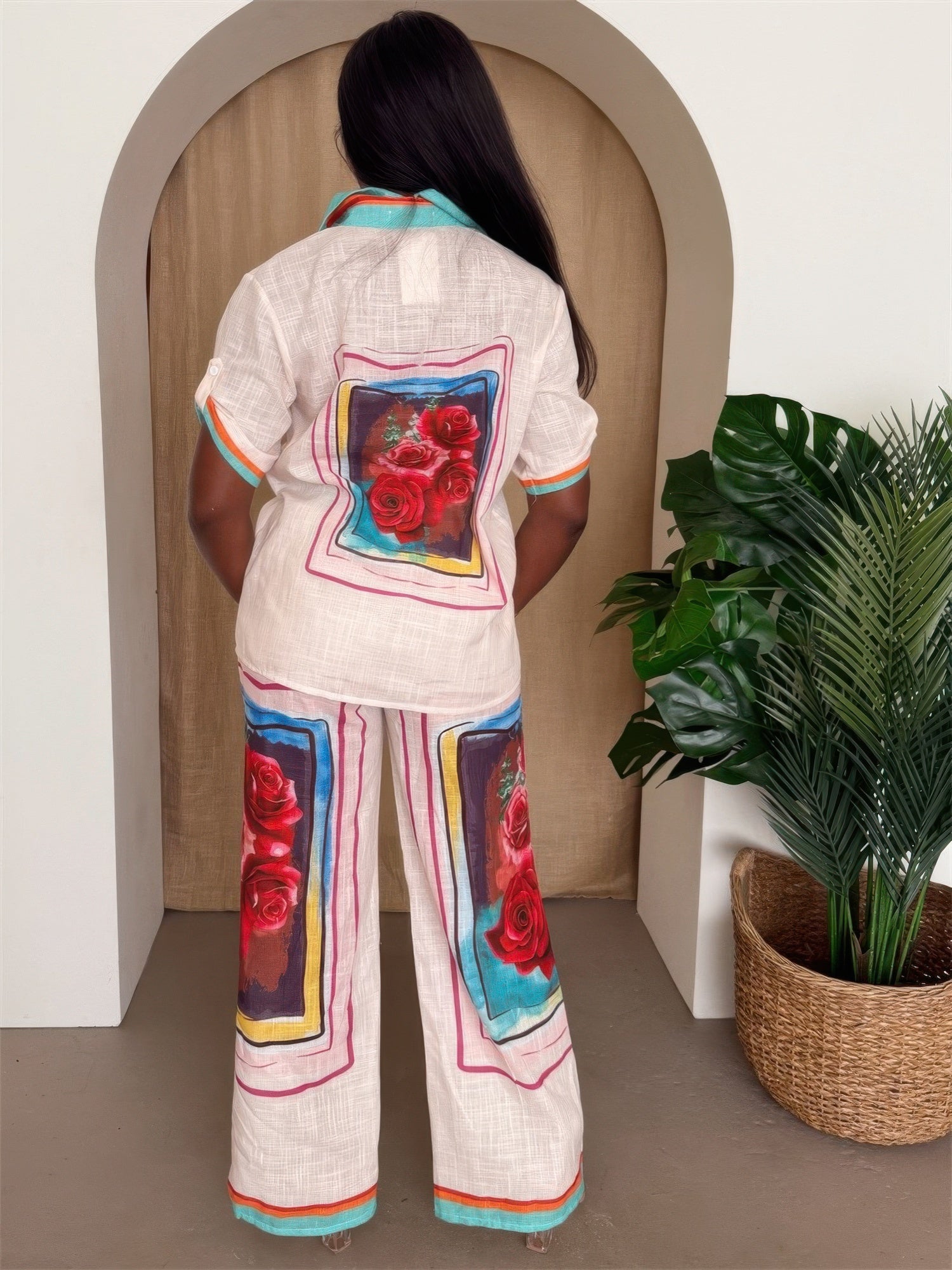 Woman wearing Fresh Roses lounge set featuring rose prints and bright color block design, standing in a stylish interior.