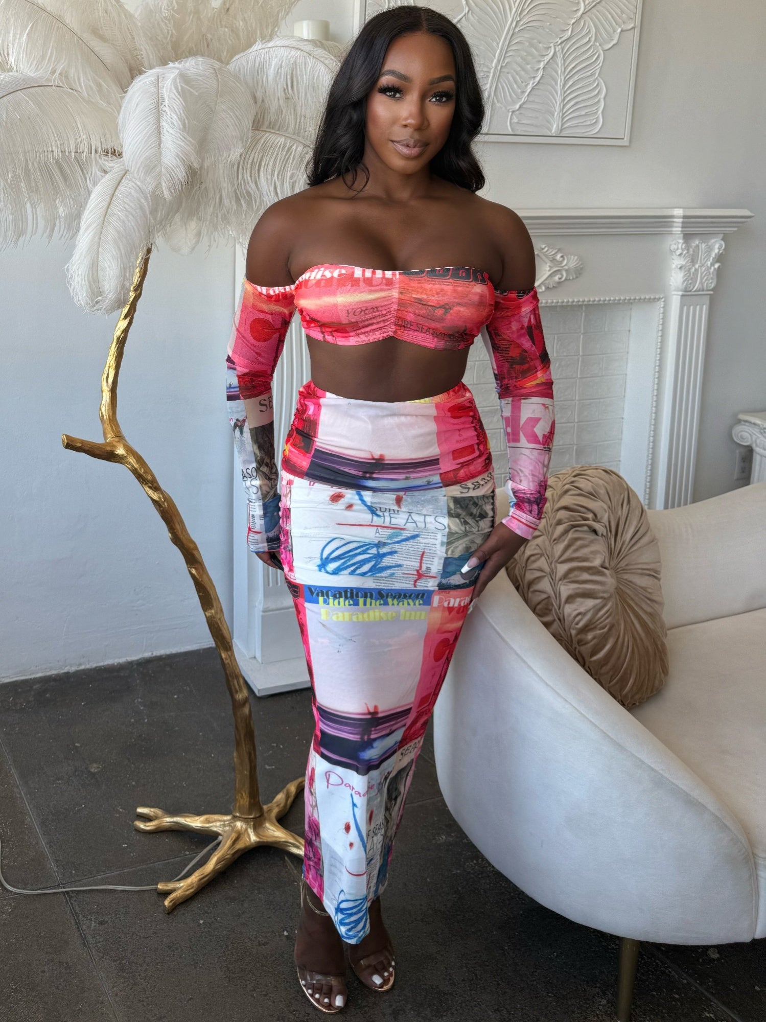 Model wearing a multi-colored mesh skirt set featuring a sheer long-sleeve top and a vibrant graphic skirt.
