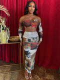 A model showcasing the two-piece skirt set featuring a ruched bandeau top and flowing mesh maxi skirt with artistic patchwork design.