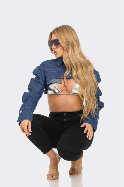 Model wearing a denim bolero jacket, styled with a silver bra, black jeans, and trendy sunglasses.