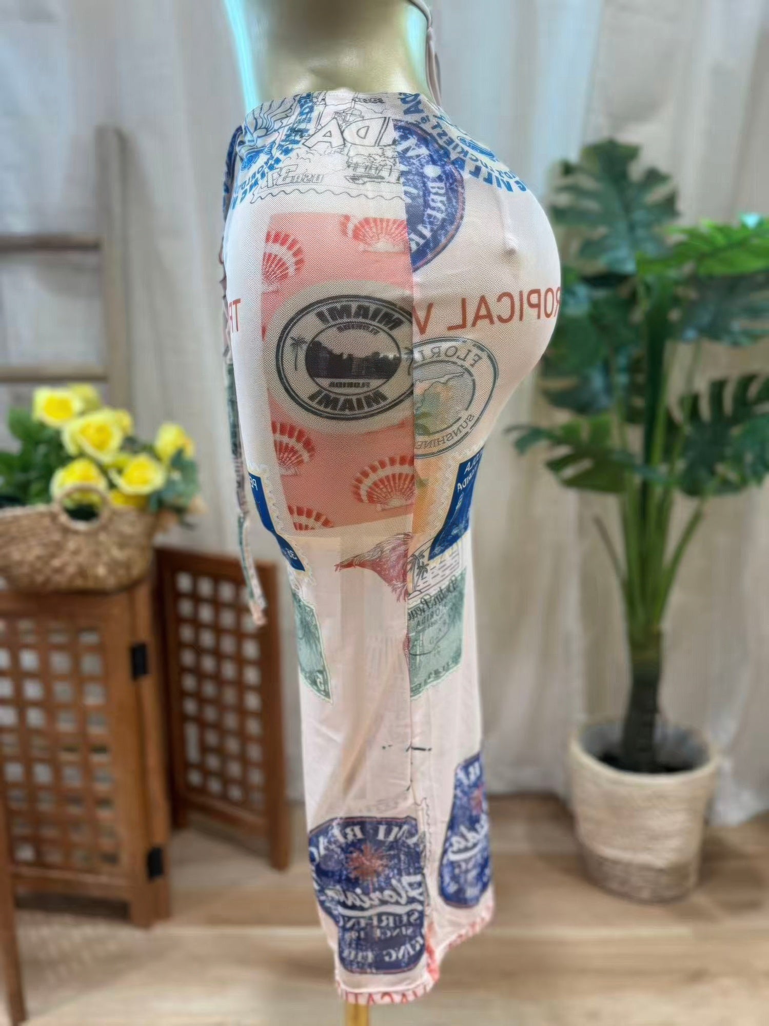 Sheer mesh midi skirt featuring vintage postcard-inspired print, perfect for beachwear styling.