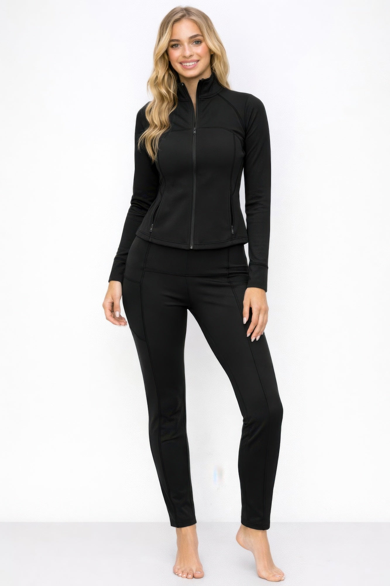 Athletic zip up jacket and pant set in black, showcasing a fitted design and stylish comfort for workouts.
