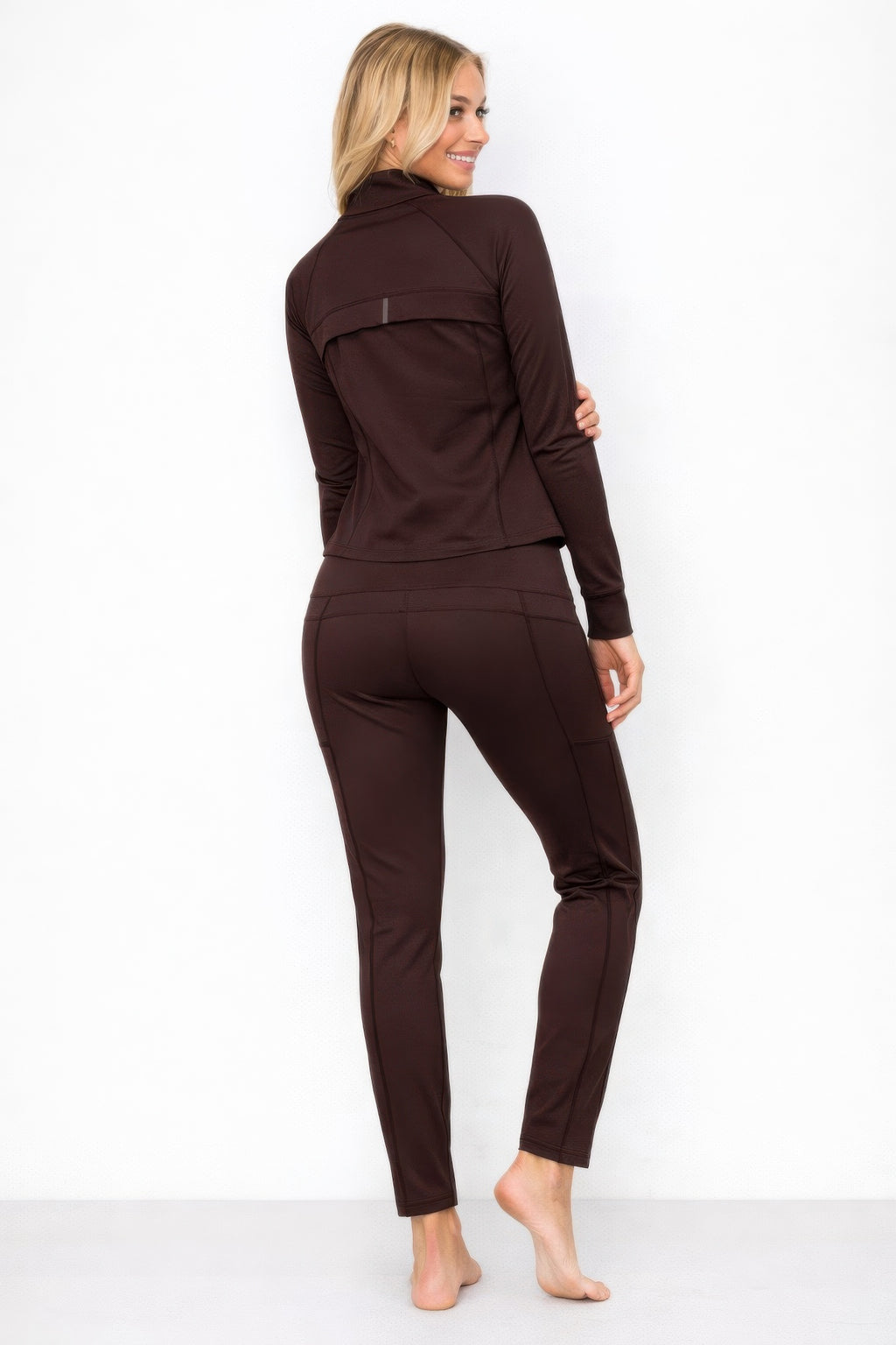 Athletic zip up jacket and pant set in brown, showcasing a fitted design and sleek silhouette from the back view.
