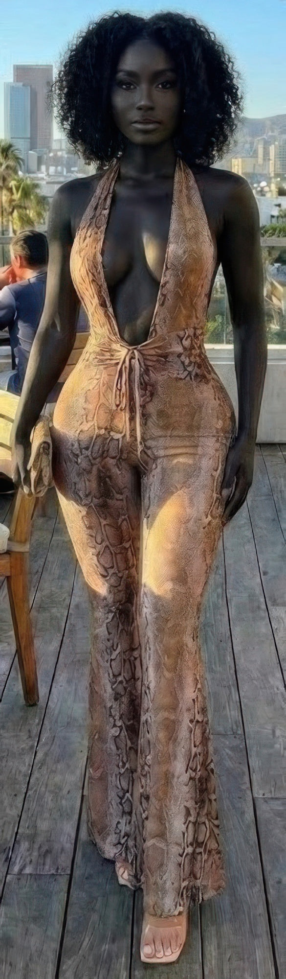 Snake Print Tie Open Back Jumpsuit on model, halter deep V neckline, fitted silhouette, statement snake pattern, adjustable tie detail