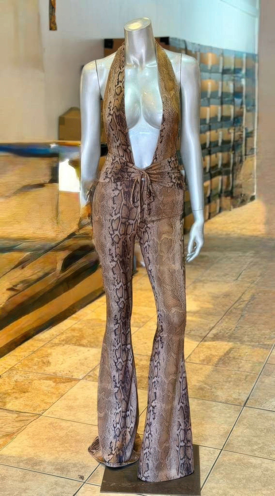 Snake Print Tie Open Back Jumpsuit on mannequin, halter neckline with open back and adjustable tie, sleek tailored silhouette