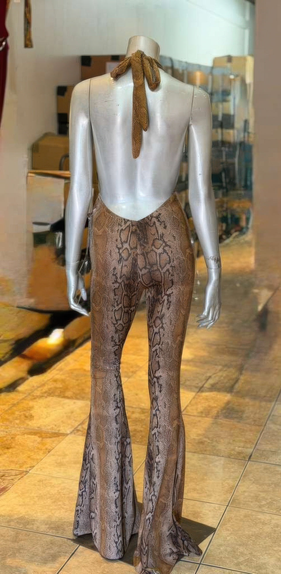 Alt Tag: Snake Print Tie Open Back Jumpsuit on mannequin, back view with tie-neck open back and flared legs in snakeskin pattern