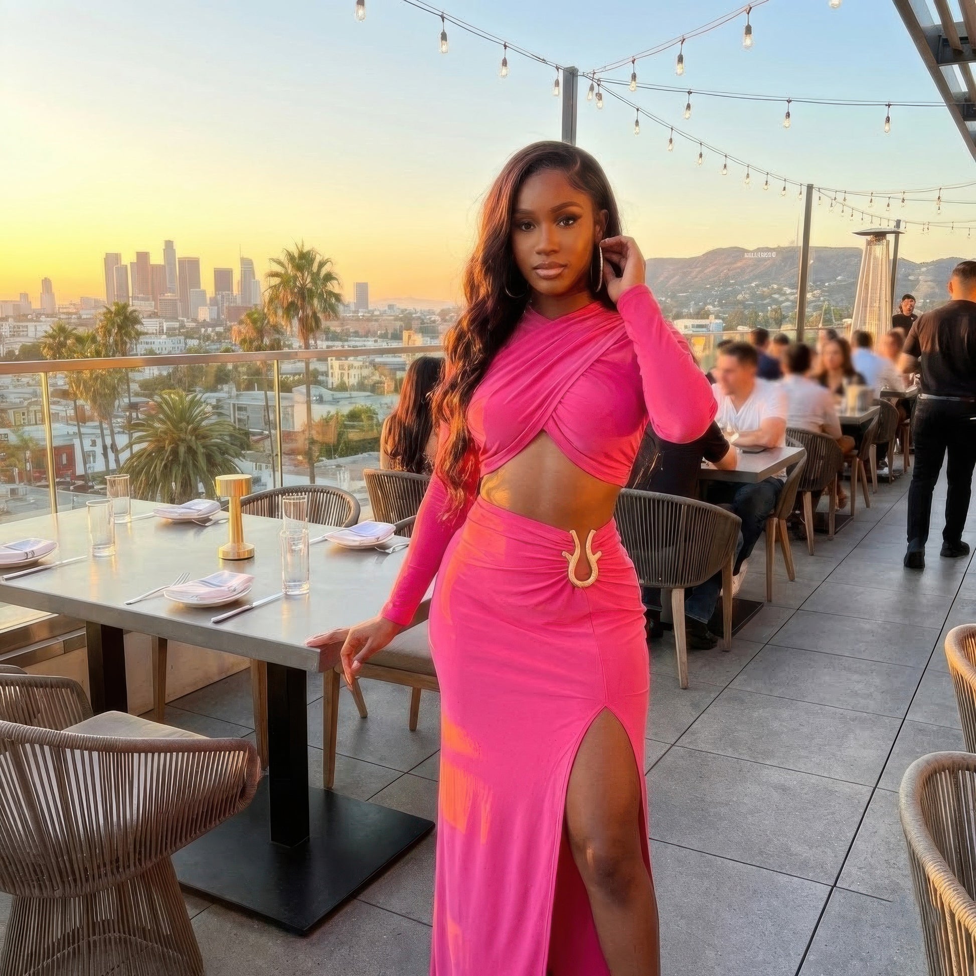 High Slit Maxi Skirt Set in hot pink with long sleeve wrap crop top and high side slit maxi skirt, worn on rooftop patio at sunset