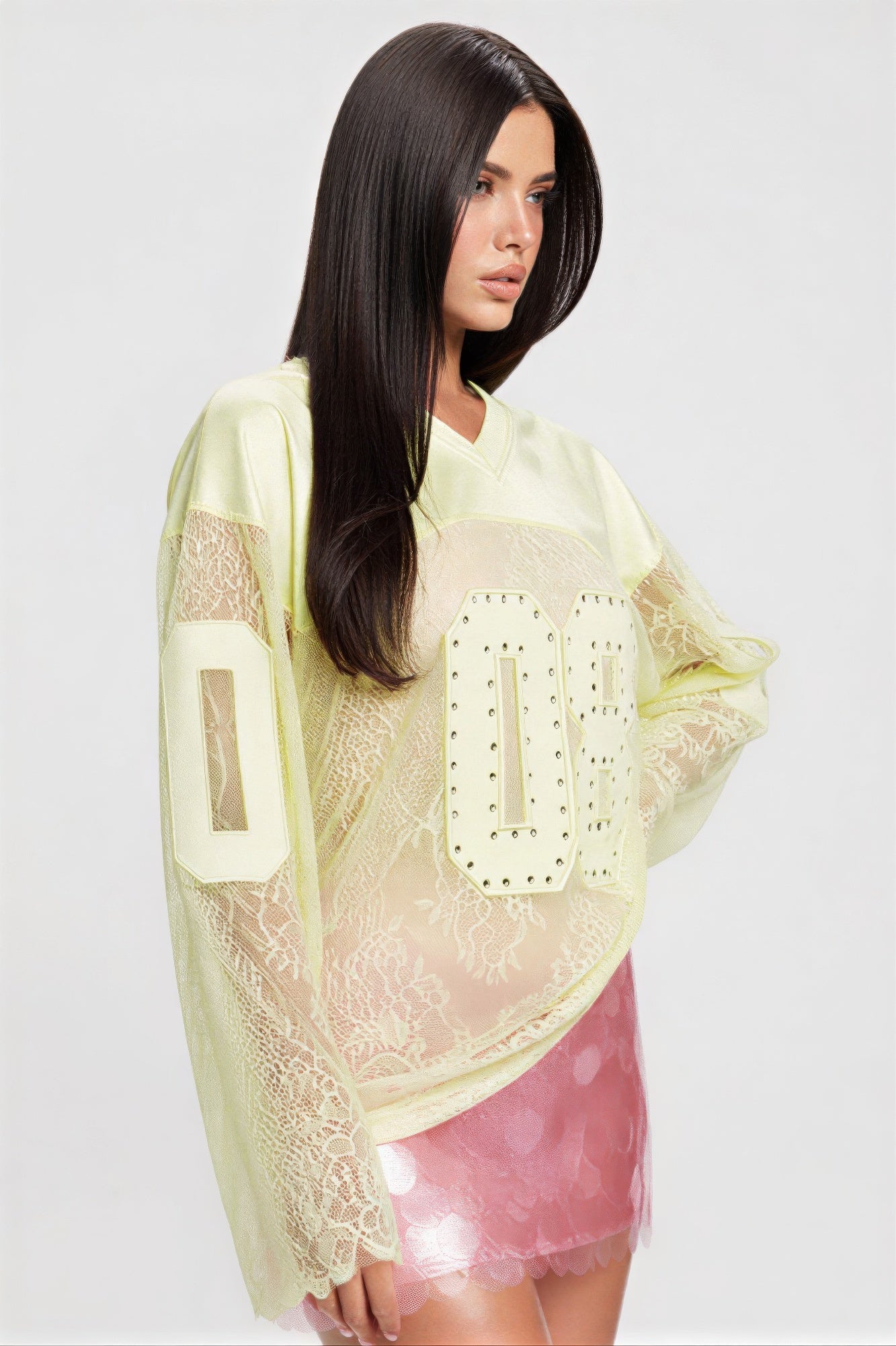 Long sleeve jersey top with graphic featuring rhinestones and lace detailing, styled with a pink skirt.