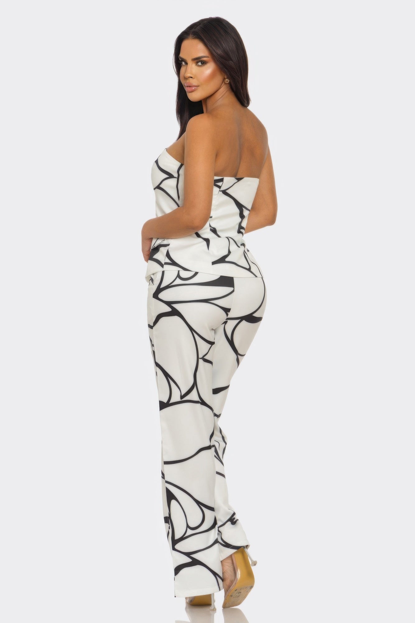 A model showcasing the abstract two-piece set featuring a strapless top and high-waisted trousers.
