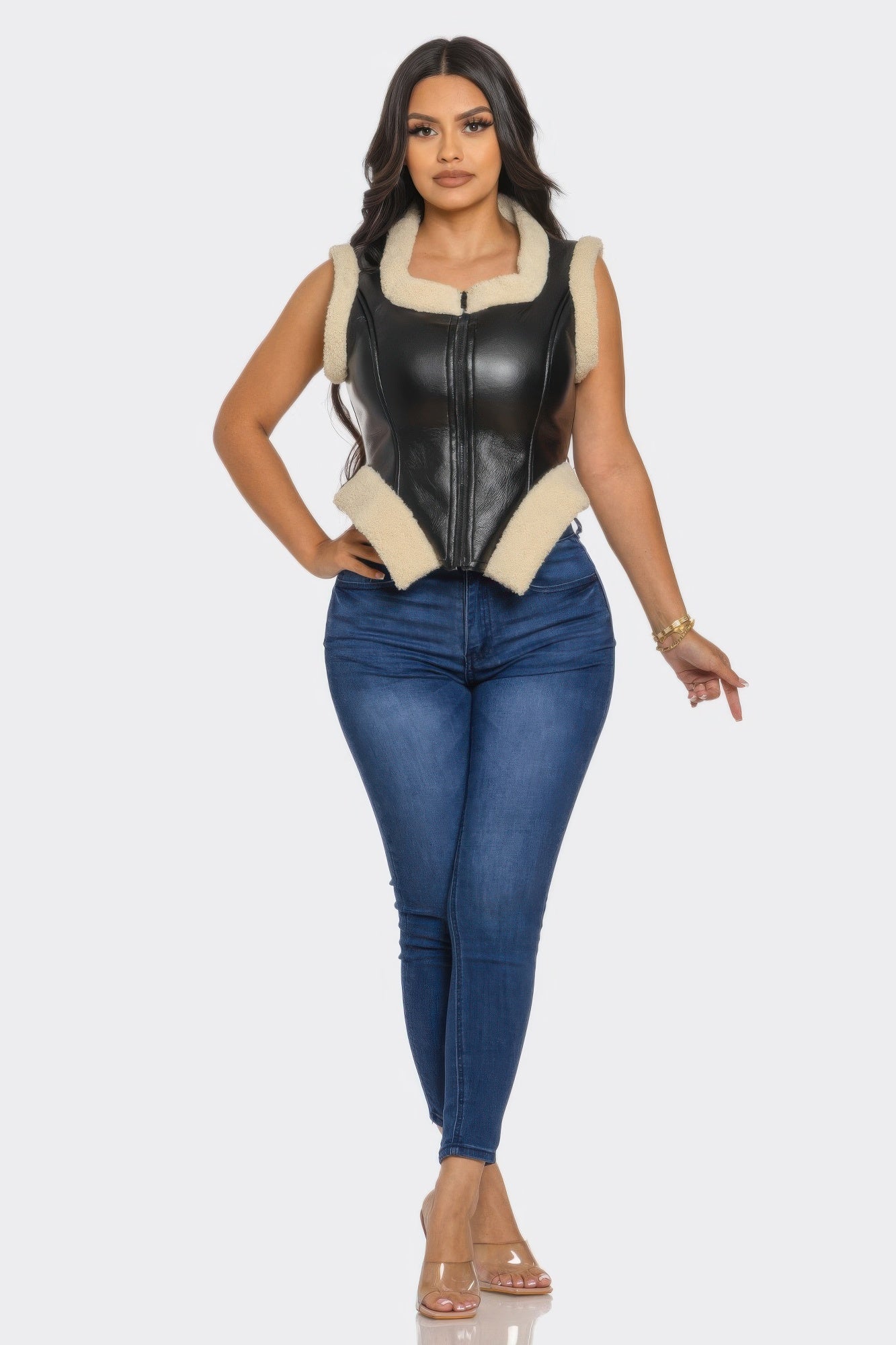 Model showcasing a V trimmed leather vest paired with fitted jeans, highlighting modern style and elegant design.