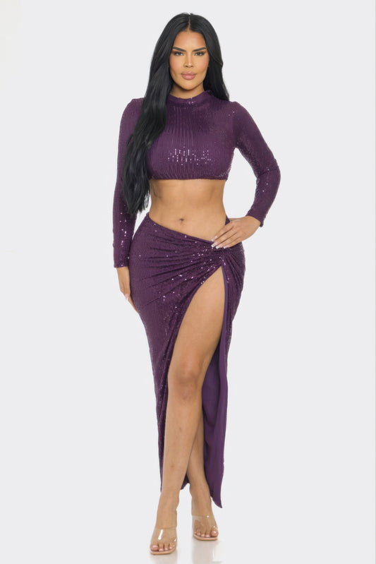 Model wearing a stylish sequin two-piece set with long sleeve top and twist front skirt.