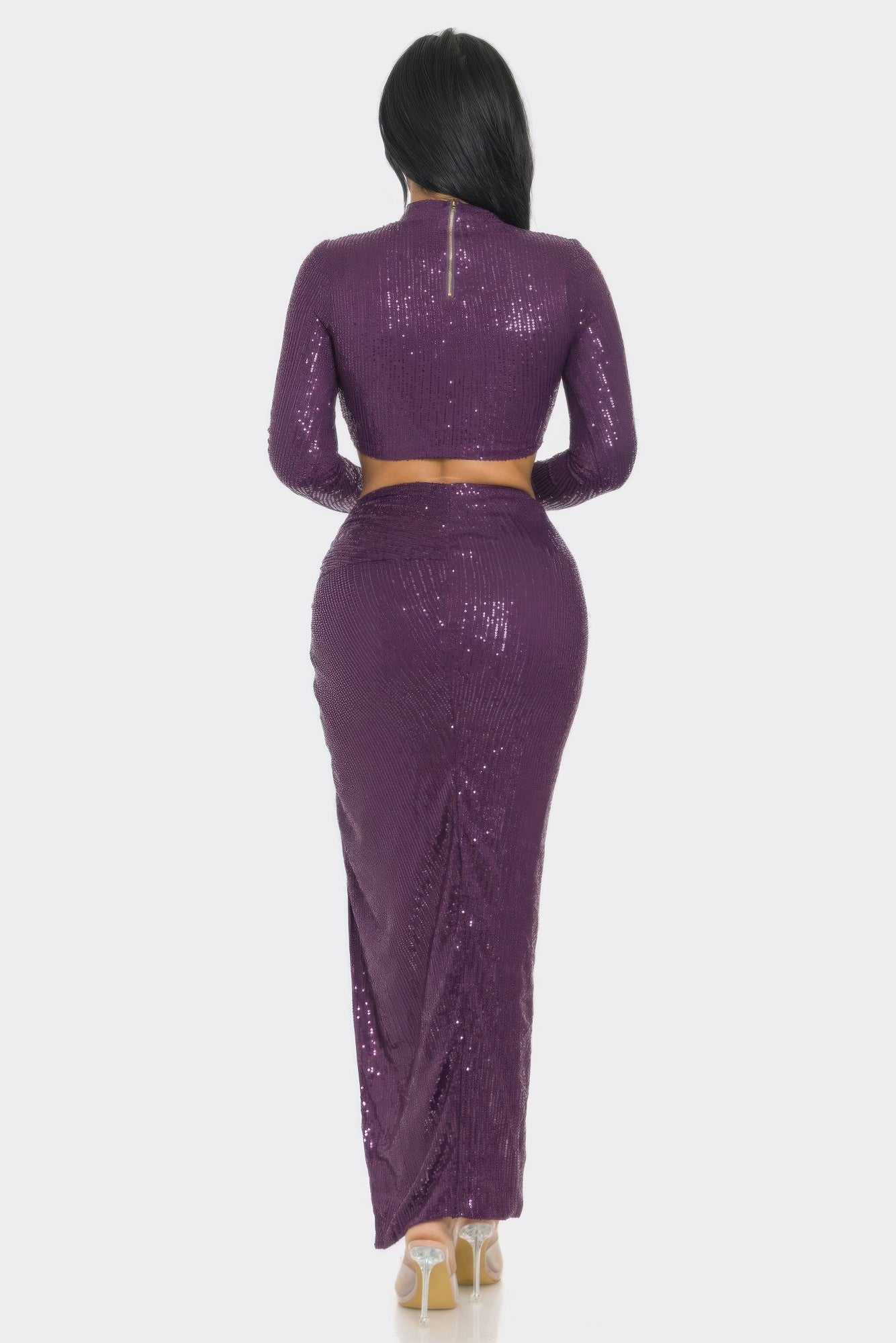 Back view of a purple sequin two-piece set featuring a long sleeve top and a twist front skirt.