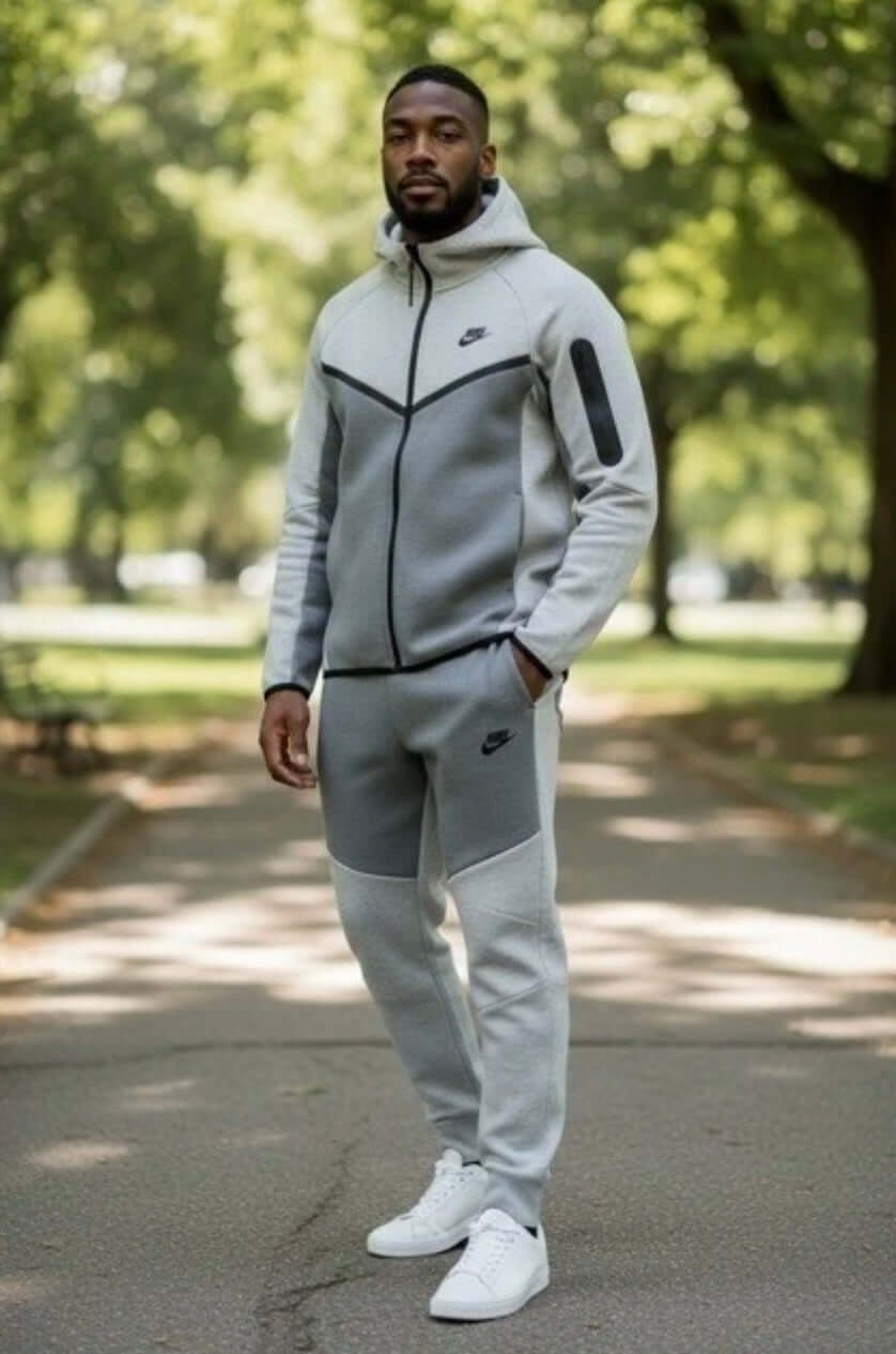 Men's Tech Lightweight Fleece Sweatsuit in a park, showcasing zip hoodie and joggers for street luxe style.