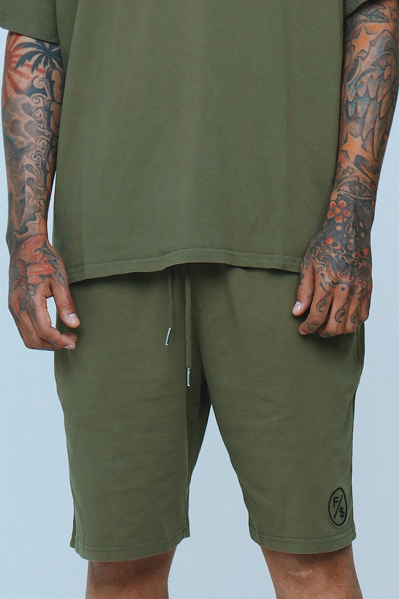 Oversized streetwear shorts featuring a relaxed fit and elastic waist, styled in an olive green color.