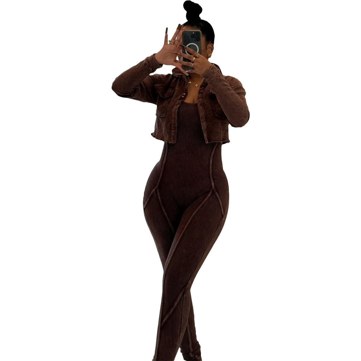 Person wearing a brown ribbed outfit taking a mirror selfie on a white background