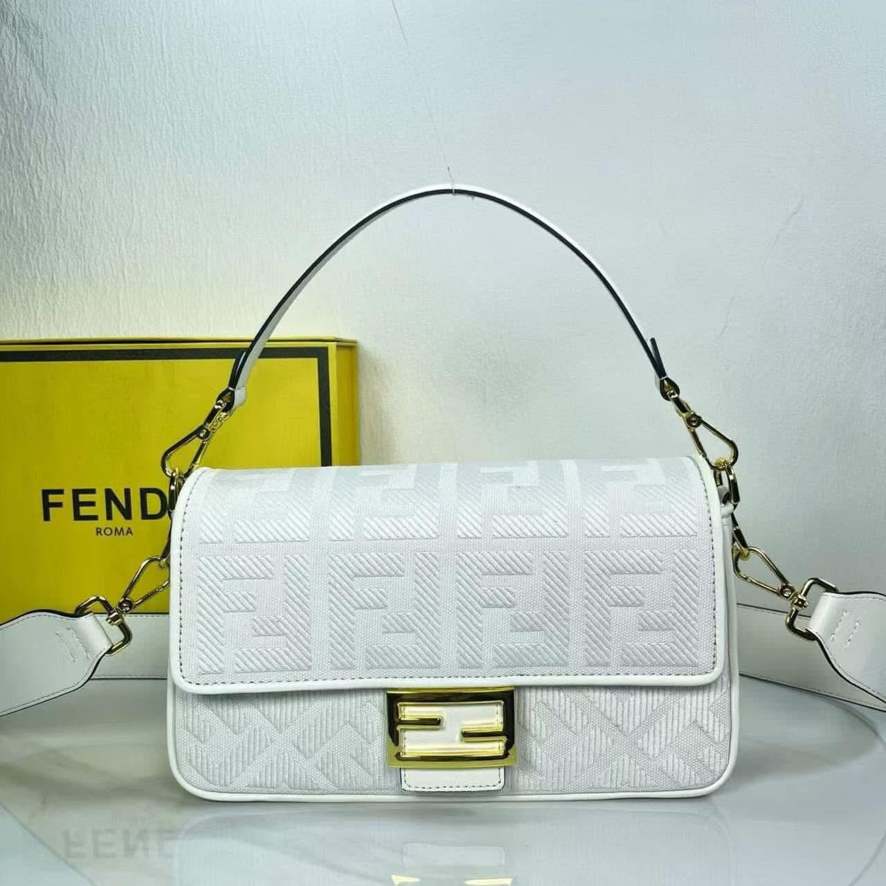 Geometric embroidered canvas handbag displayed with a Fendi box, showcasing a stylish white design and gold accents.