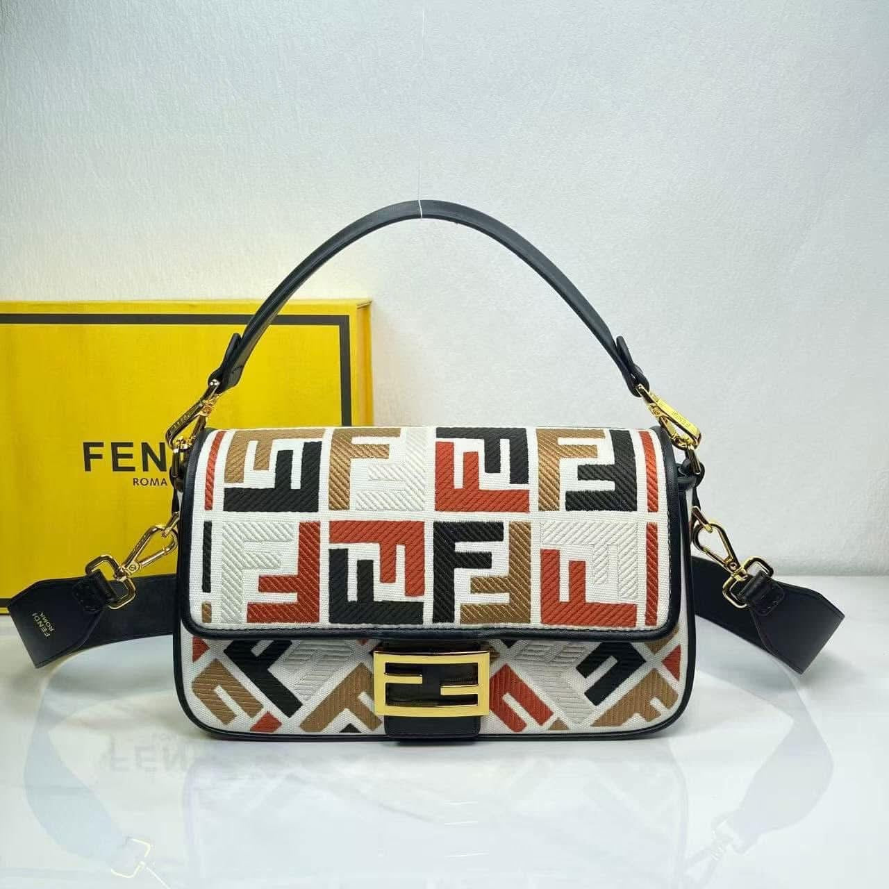 Designer handbag with geometric pattern in front of a yellow Fendi box.